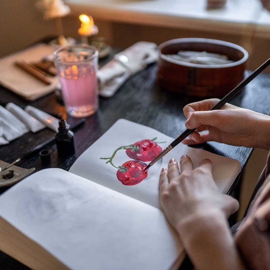 Photograph of an artist painting in a sketchbook